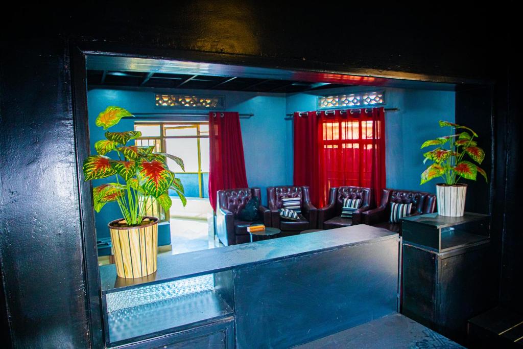 基加利Albina Motel的蓝色的房间,里面摆放着椅子和植物