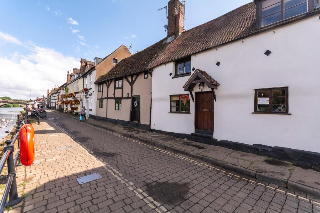 布由德利Bewdley River Cottage - Free private gated parking for 2 cars - River front location的白色建筑城镇中的鹅卵石街道