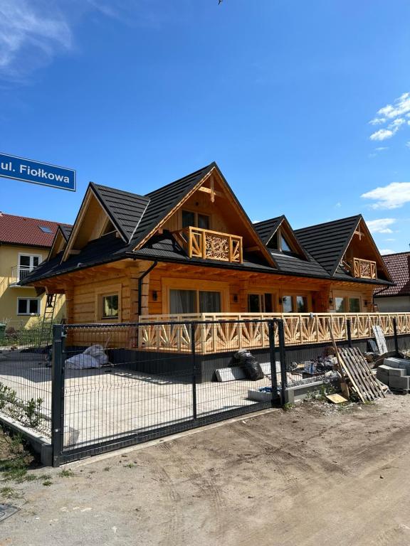 辛安诺泽蒂Roomflacja Bałtyk的小木屋前面设有围栏