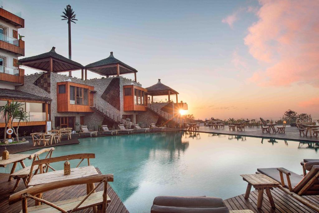 沃利迪耶Chateau Eden El Rouh & Spa的度假村的游泳池,配有椅子和日落