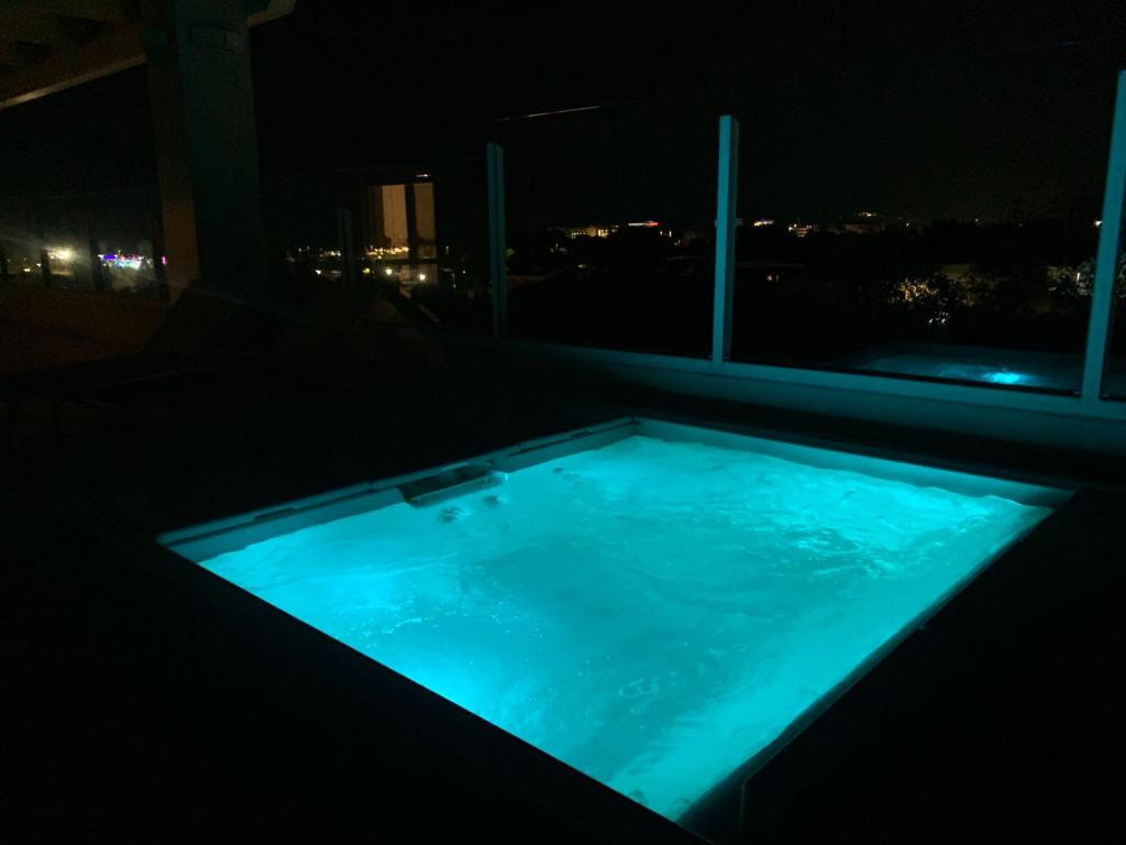 米萨诺阿德里亚蒂科Suite Luxury Seaview的一个带按摩浴缸的房间,晚上有窗户