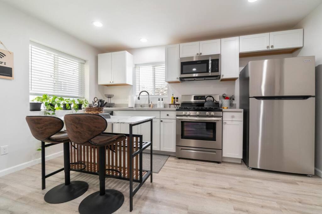 圣地亚哥Urban Oasis: San Diego Bungalow Escape的厨房配有白色橱柜和不锈钢用具