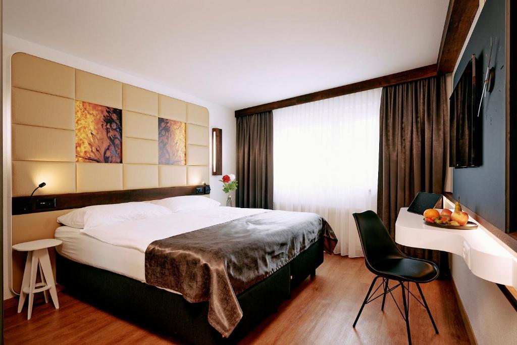 菲斯普伊里特酒店的酒店客房设有一张大床和一张桌子。