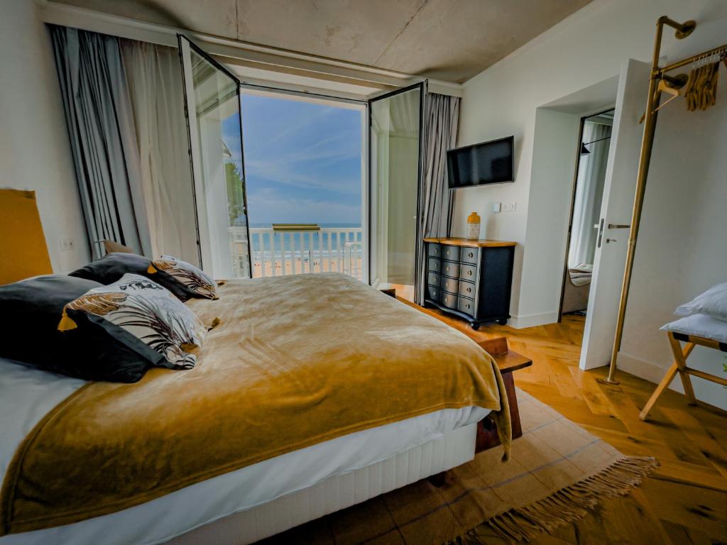 波尔尼谢La Maison Régent & spa face à la mer的一间卧室设有一张大床和大窗户