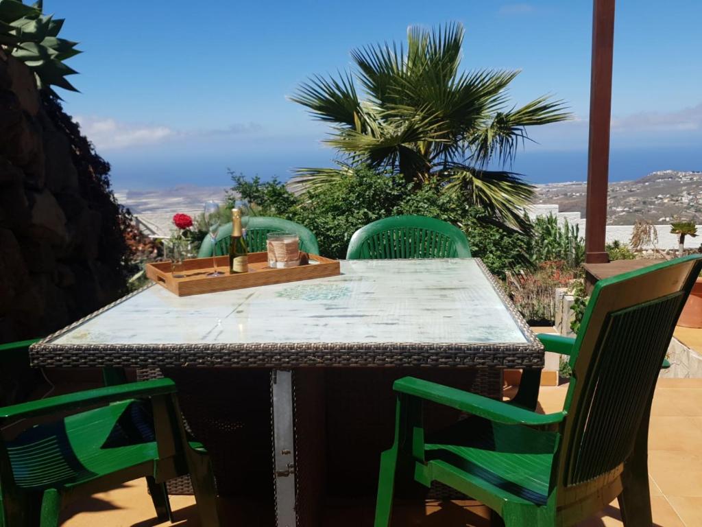 圣米格尔德阿沃纳Lo mejor de la montaña, Vista Bonita的天井上配有带绿色椅子的桌子