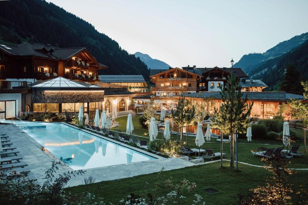 格罗萨尔Familien Natur Resort Moar Gut的大楼前设有游泳池的酒店