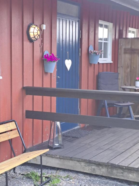 克拉姆福什Klockestrandstugan-Höga kusten的蓝门房子前面的长凳