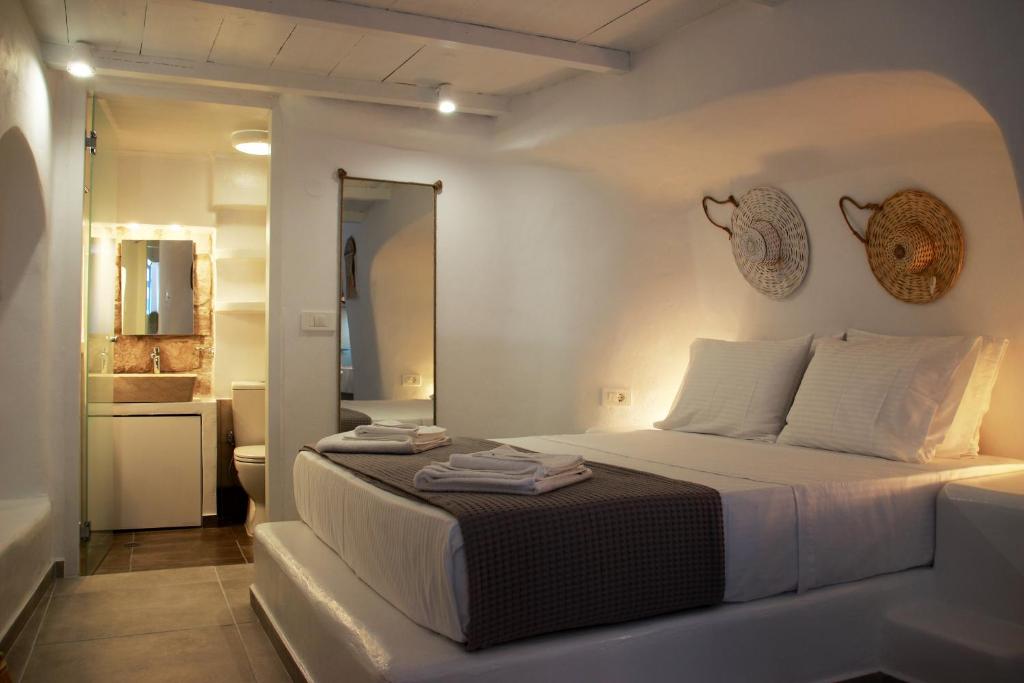 Mandrakiail Marinero mandrakia的一间白色卧室,配有床和一间浴室