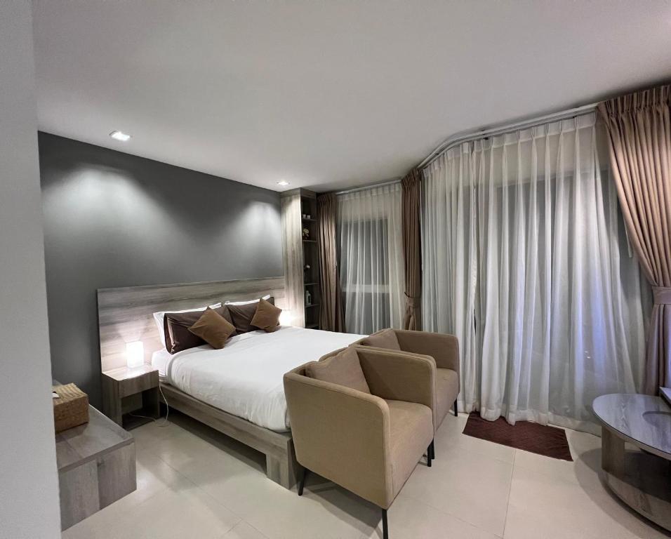 梅尔皮姆Grandblue Condominium#702 Seaview TopFloor MaePim Rayong的酒店客房,配有一张床和两把椅子