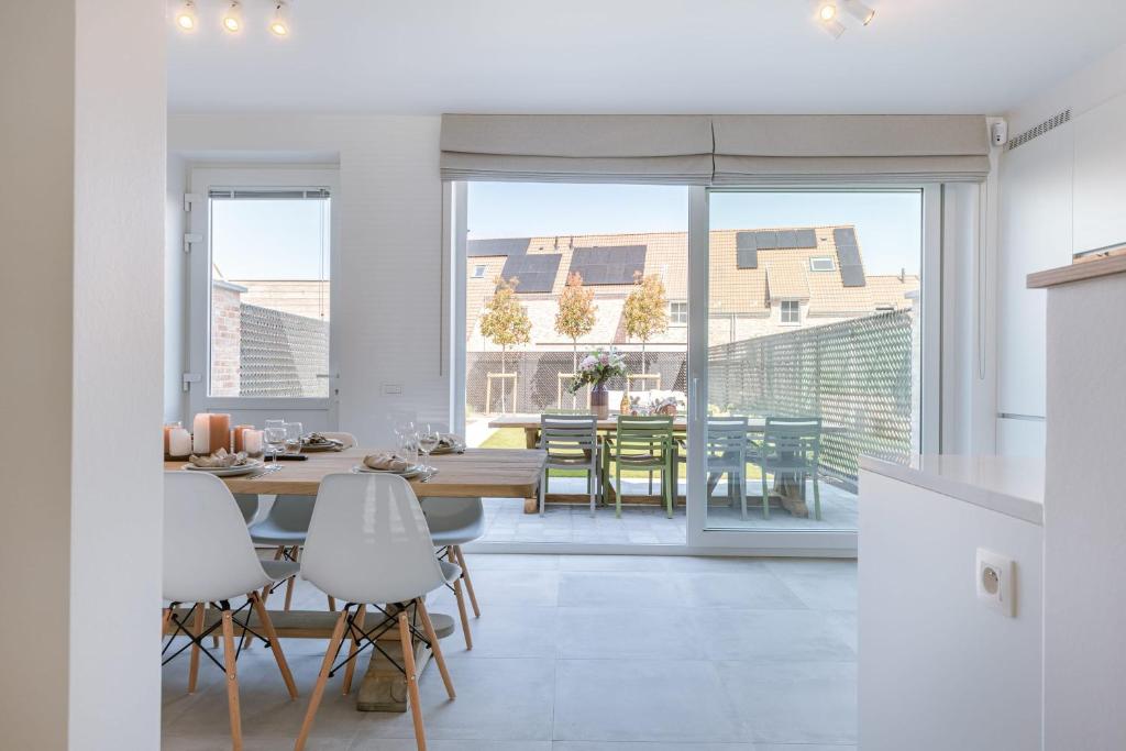 米德尔克尔克Modern house JULIE with spacious garden and garage的厨房以及带桌椅的用餐室。