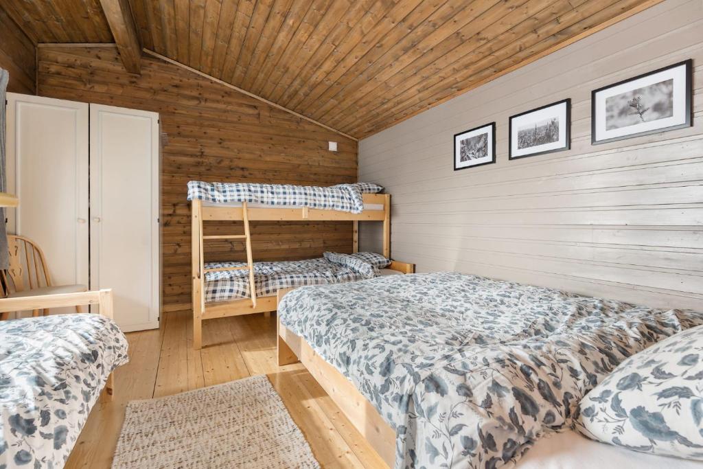 灵达尔Lyngebu. Nice family cabin with sea view.的一间卧室设有两张床和木墙