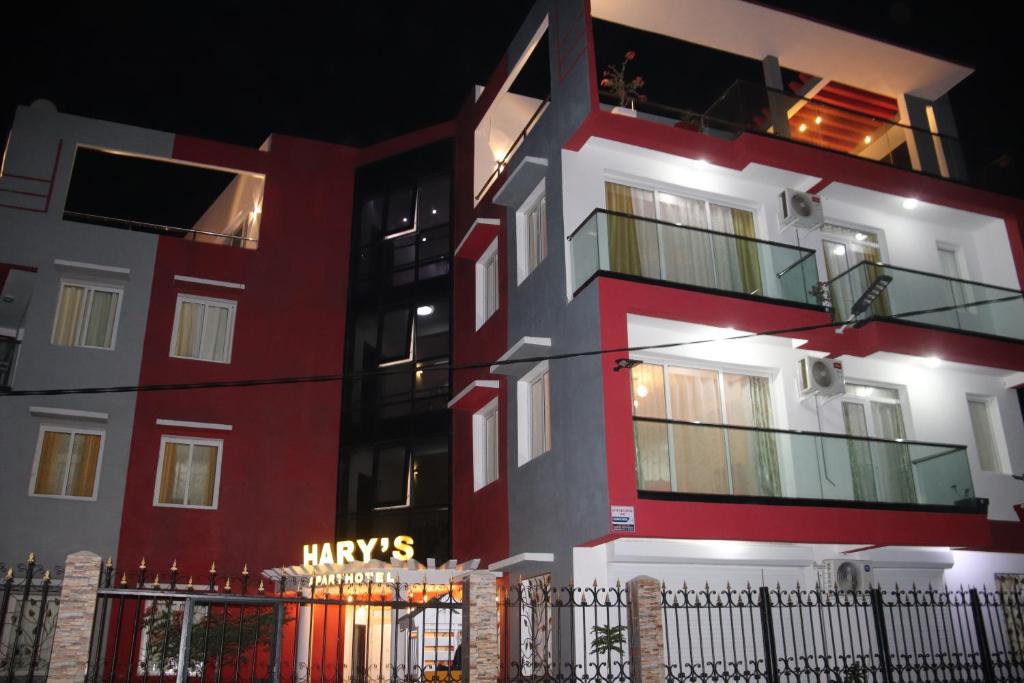 图利亚拉Hary's Aparthotel的一座红色和白色的建筑,上面有标志