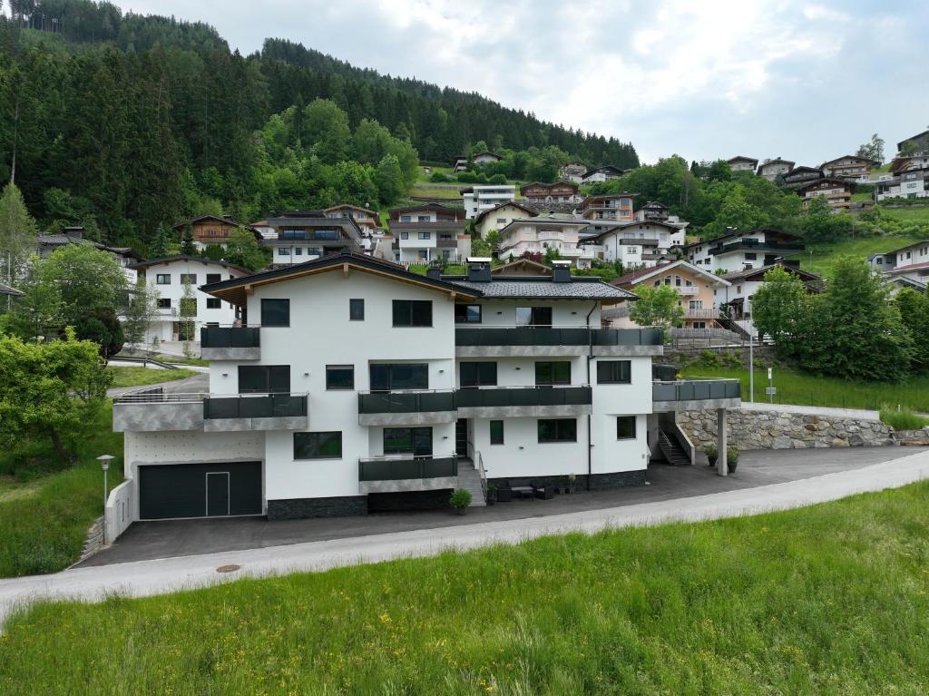 海因岑贝格Montepart Zillertal的一座白色的山丘建筑,设有房屋