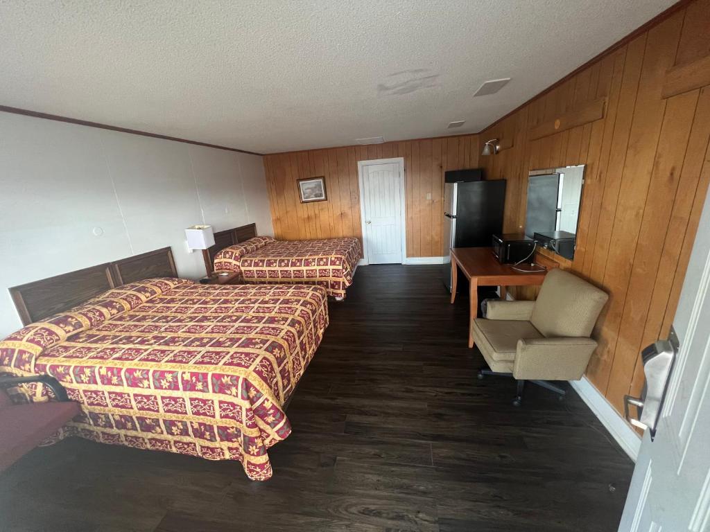 BaxleyPinelodge Motel的酒店客房配有两张床和一张书桌