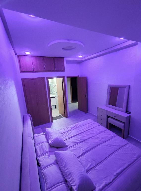 伊穆泽尔杜坎达Chalet villa QUE POUR LES FAMILLES的紫色客房,配有一张床和一台电视机