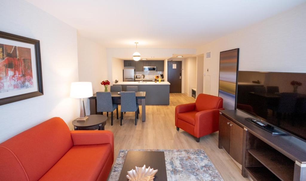 渥太华商旅套房酒店的带沙发和电视的客厅以及用餐室。