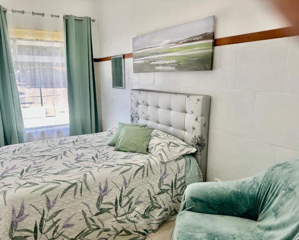 卡什塔涅拉德佩拉Sweet Home - Praia das Rocas的一间卧室配有一张床和一把椅子