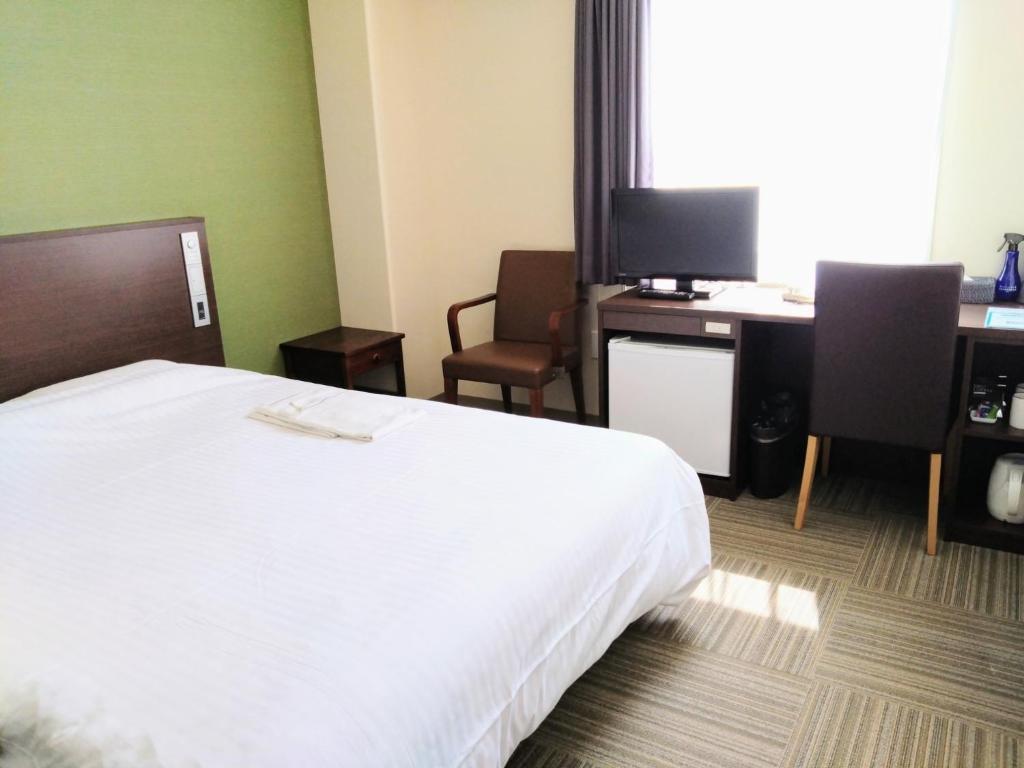 白山市New Matto Terminal Hotel - Vacation STAY 01873v的酒店客房配有一张床和一张带电脑的书桌