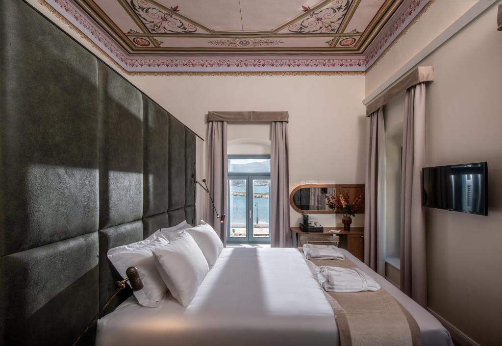 锡蒂亚Palazzo di Sitia Luxury Suites的一间卧室设有一张带天花板的大床