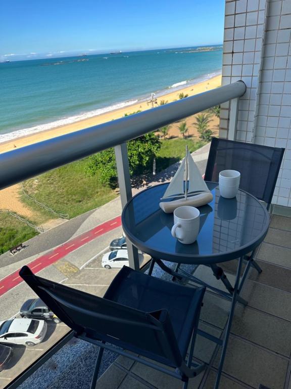 维拉维尔哈Apartamento Renovado na beira da Praia的阳台上的桌子和两把椅子,还有一艘船