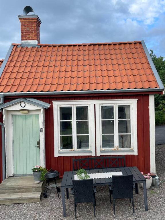 格兰纳Gårdshus - best location in the center of Gränna的红色和白色的房子,配有桌子和椅子