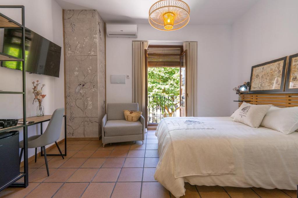 阿尔卡拉拉雷亚尔Casa el Aguardentero的一间卧室配有一张床、一张桌子和一把椅子