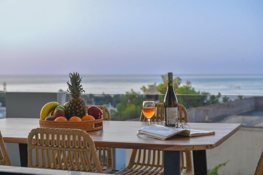 GállosLeon Luxury Home in Rethymno的一张桌子,上面放着一篮水果和一瓶葡萄酒