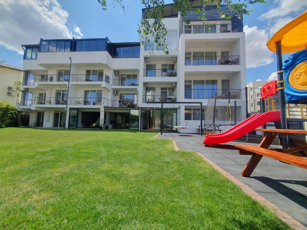 北马马亚-讷沃达里MIANELLY Apartments Mamaia Nord的公寓大楼设有游乐场和滑梯