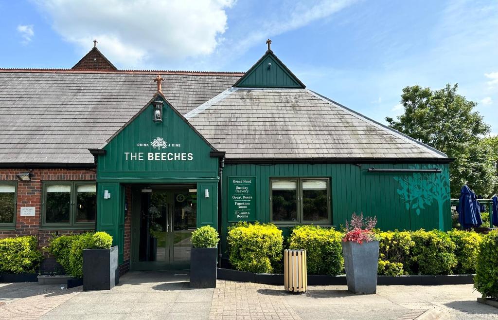 阿什比德拉祖什The Beeches, Ashby-de-la-Zouch的一座绿色建筑,上面有读啤酒厂的标志