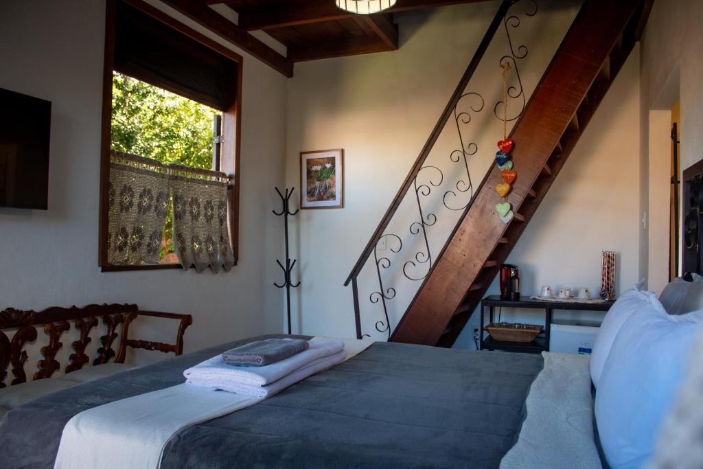 穆库热Villa Santo Antonio - Mucugê的一间卧室配有一张床和一个楼梯间