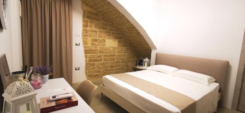 乌真托TORRE VECCHIA RELAIS的酒店客房配有一张床铺和一张桌子。