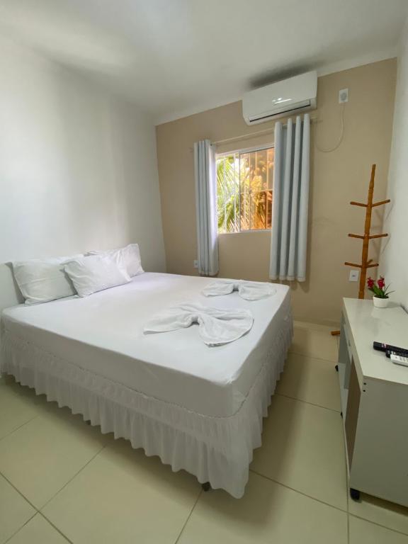 皮拉尼亚斯Pousada Girassol的卧室配有白色的床和窗户。