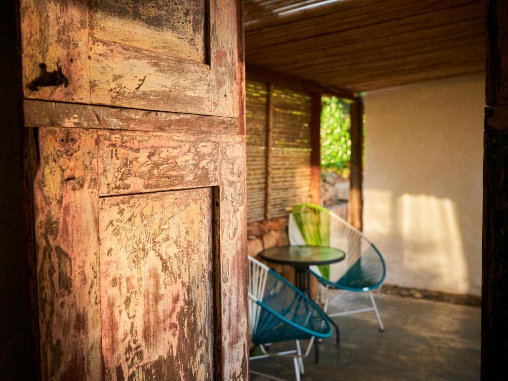 洛斯桑托斯Hostal Juan Palitos的开放式木门,配有桌椅