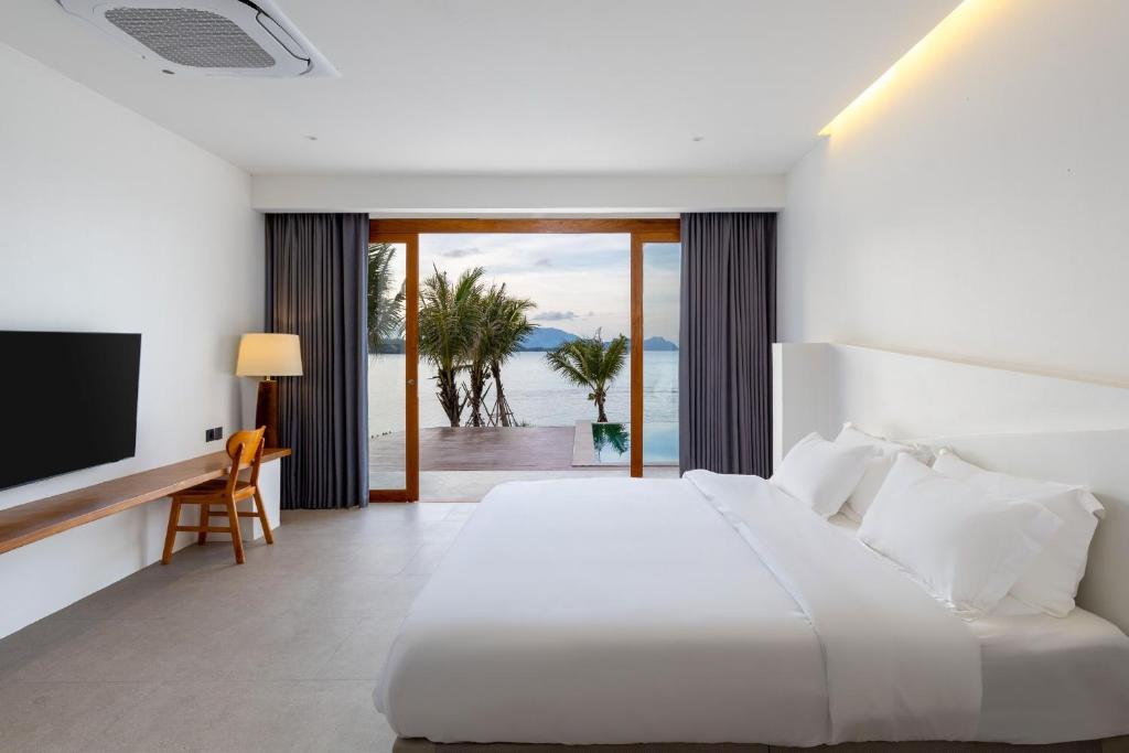 卡农X-Sea Khanom Harbor Bay Resort的卧室配有白色的床和电视。