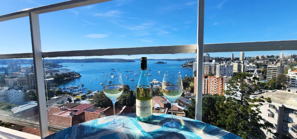 悉尼Expansive Harbour Views的两杯酒坐在窗前的桌子上