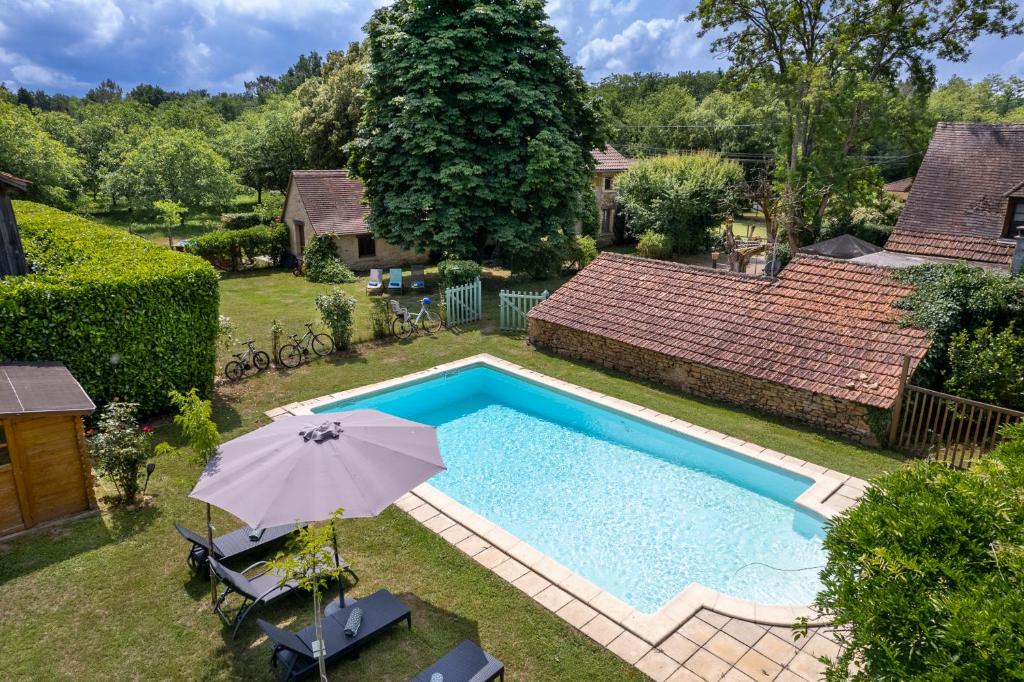 特雷莫拉The cottage at Les Chouettes Tremolat的游泳池顶部景,带遮阳伞