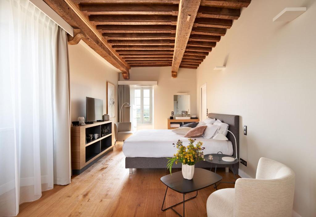 蒙帕齐耶hideauts hotels Le Chevalier bleu的一间卧室配有一张床、一张沙发和一张桌子