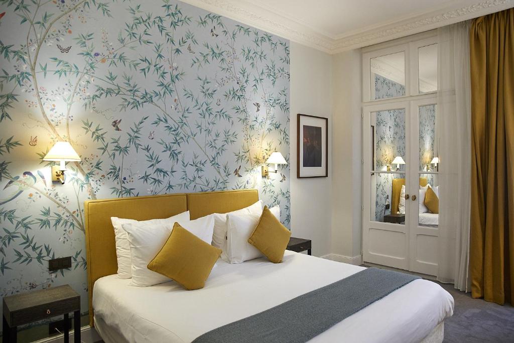巴黎多瑙河圣日耳曼酒店的一间卧室配有一张蓝色花卉壁纸床