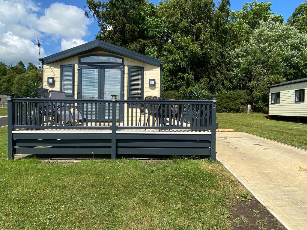 SwarlandCosy & Modern Cabin In Heart of Northumberland的凉亭,草地上设有长凳