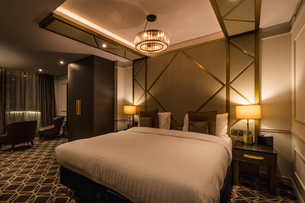 滨海绍森德赛文酒店的酒店客房设有一张大床和吊灯。