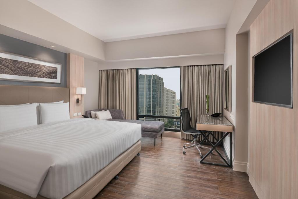 宿务Seda Central Bloc Cebu的酒店客房配有一张床、一张书桌和一台电视。