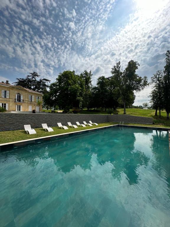 贝沙克和凯洛Chateau Erigoye的一座带躺椅的游泳池和一座建筑