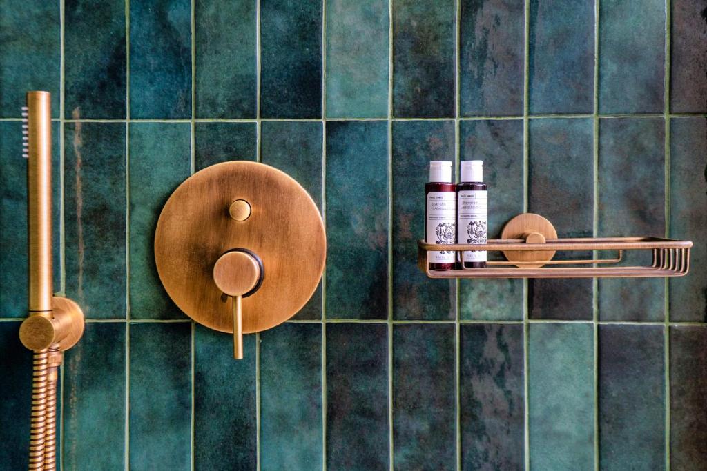 阿梅尼斯蒂斯Selene的浴室设有绿色瓷砖墙壁、两个架子和化妆品