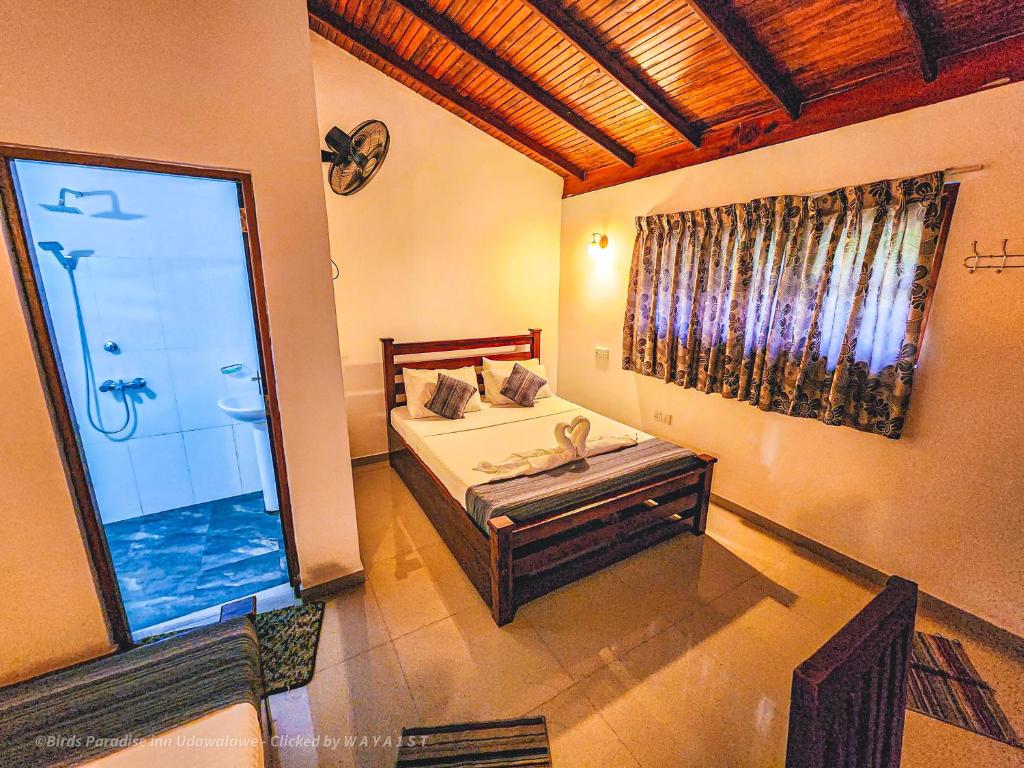 达瓦拉维天堂鸟公寓的一间卧室设有一张床和一个大窗户