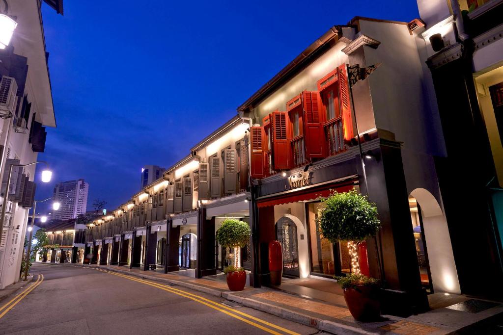 新加坡The Scarlet Singapore的一条晚上有一排建筑物的街道