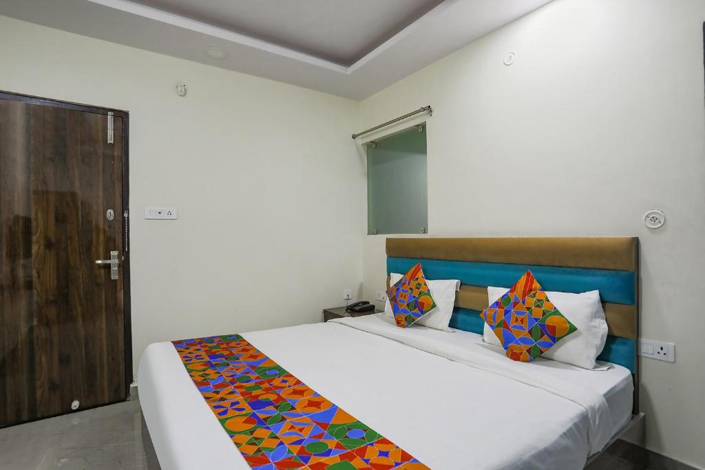 ChinhatFabHotel SM Palace的一间卧室配有一张带彩色毯子的床
