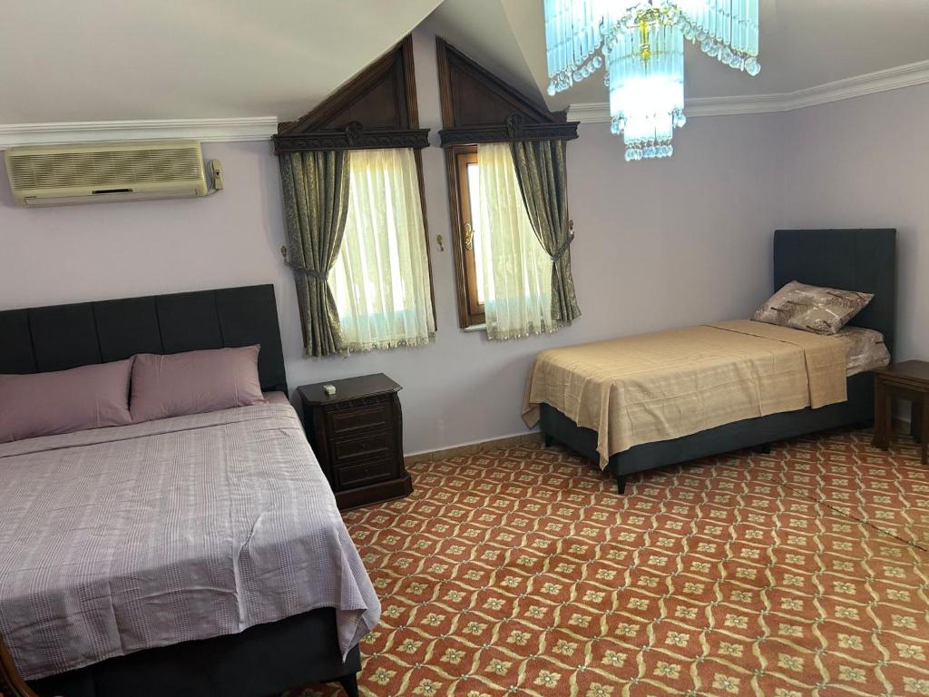 PelitliKARTAL APART的一间卧室配有两张床和吊灯。