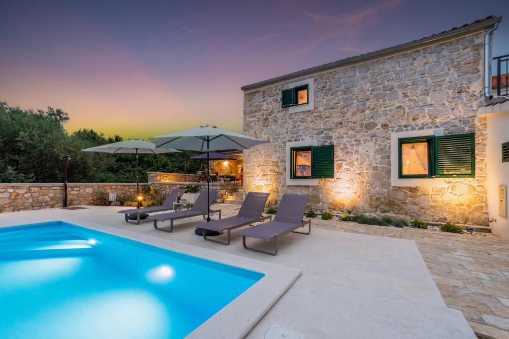 波利亚纳Stone House Luna的别墅设有游泳池和庭院家具。