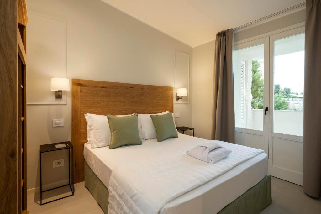 努马纳Borgopetra Resort的一间卧室设有一张大床和一个窗户。