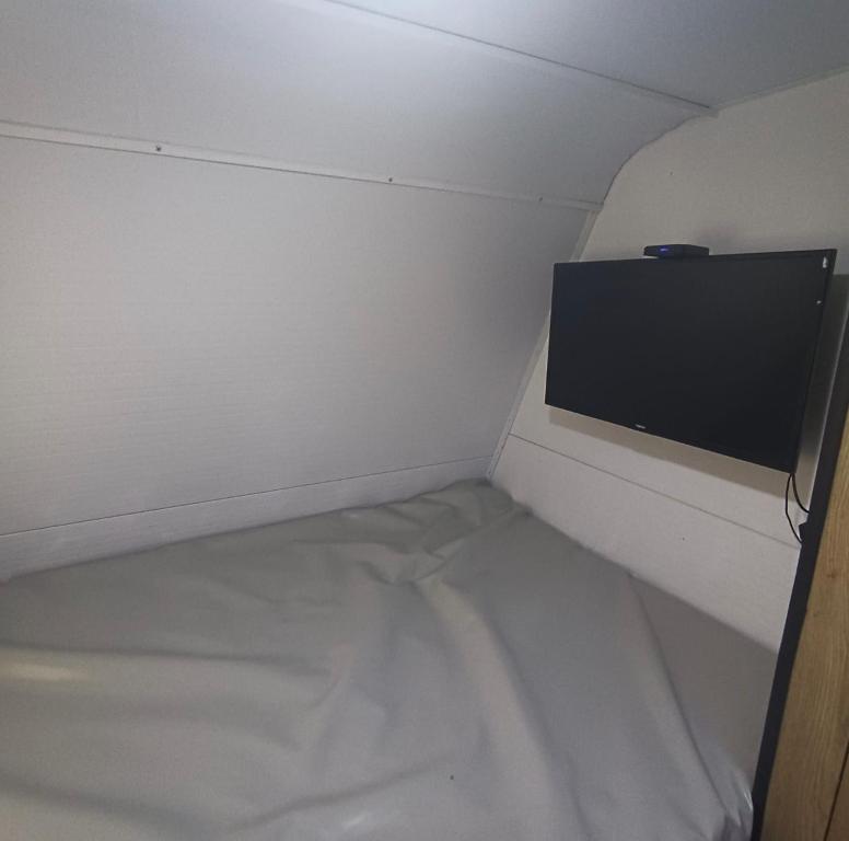 特拉维夫האירוח המושלם בקטנה בקרוואן的小房间设有一张床和一台平面电视